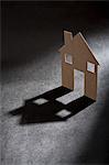 Cardboard house shape casting shadow
