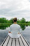 Man meditating on wooden pier