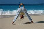 Woman practicing yoga on tropical beach