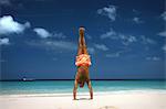 Man doing handstand on tropical beach