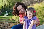 Mother and daughter sitting outdoors