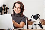 Woman using laptop with dog