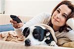 Woman watching television with dog