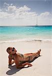 Smiling woman sunbathing on beach
