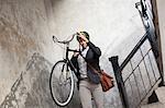 Man carrying bicycle down staircase