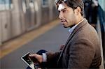 Man using tablet computer at station