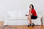 Businesswoman with cell phone on sofa