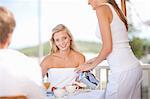 Waitress serving woman coffee at table