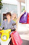 Couple carrying shopping bags on scooter