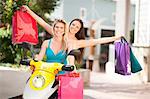 Women carrying shopping bags on scooter