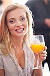 Woman having orange juice in cafe