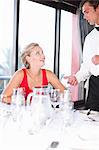 Woman talking to waiter at restaurant