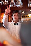 Waiter offering more drinks at bar