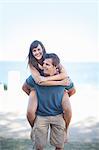 Man carrying girlfriend on beach