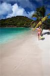 Woman carrying fins on tropical beach