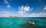 People rowing canoe in tropical water