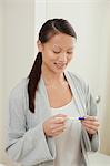 Woman taking pregnancy test in bathroom