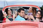 Friends toasting in convertible