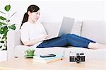 Woman using laptop on the sofa