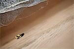 South America, Brazil, Ceara, Fortaleza, Aerial view of a yellow beach buggy driving along a beach between Jericoacoara and Fortaleza