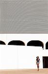 South America, Brazil, Brasilia, Distrito Federal, model walking in front of the Leonel de Moura Brizola National Library on the Esplanada dos Ministerios by Oscar Niemeyer MR