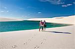 South America, Brazil, Maranhao, a honeymoon couple look out over a scene of dunes and lakes in the Lencois Maranhenses