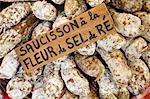 France, Charente Maritime, Ile de Re.  Saucisson or whole salamis dusted with salt harvested from the salt flats on the Ile de Re, on a market stall in Les Portes.