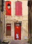 France, Provence, Arles, girl with Baguette at red doorway MR