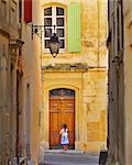 France, Provence, Arles, girl with Baguette at doorway MR