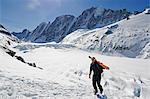 Europe, France, French Alps, Haute Savoie, Chamonix, skier carrying sis uphill in the Col du Passon off piste ski touring area MR