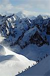 Europe, France, French Alps, Haute Savoie, Chamonix, Aiguille du Midi, skiers walking down the ridge at the start of Vallee Blanche off piste