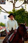 Seville, Andalusia, Spain, A Spanish girl in Traditional Andalusian clothes riding a horse during the Feria de Abril