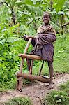 A proud young boy with his homemade wooden bicycle, which still lacks wheels, Uganda, Africa