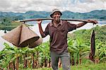 A jovial fisherman with fishing baskets and his catch of the day, which he caught in Lake Mutanda, Uganda, Africa