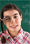 Close-up of Girl with Magnifying Glass in Classroom
