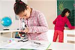 Girl Looking at Flower with Microscope in Classroom, Baden-Wurttemberg, Germany