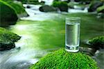 Glass of water near a mountain stream