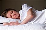 Portrait of sleeping woman on her bed in her bedroom.