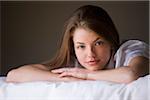 Portrait of woman lying on her bed in her bedroom.