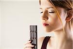 Teenage Girl holding Chocolate with Eyes Closed, Studio Shot on White Background