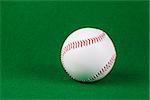 Single white baseball softball on green background