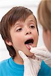Boy showing her throat to health professional sticking his tongue out