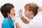 Doctor taking saliva sample from little boy - childhood infectious diseases