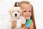 Little girl loves her fluffy dog posing together for the camera