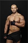 A well ripped and fit Muscular Brazilian man with Training Gloves