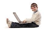 Sitting child using a laptop and smiling