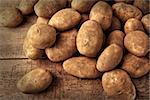 Fresh potatoes on rustic wooden background