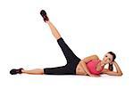 Beautiful woman doing a workout lying on her side on the floor with her leg raised in the air to exercise and strengthen her muscles