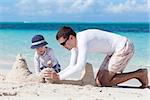 little kid and his father building sandcastle