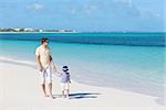 young man with his son walking at the beach